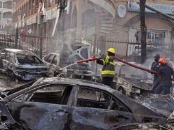 Hombres auxilian a una mujer tirada en el piso luego de la explosión en el centro comercial. AP /