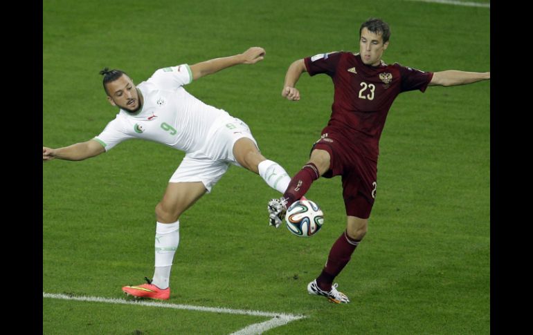 Acción de juego entre Nabil Ghilas de Argelia y Dmitry Kombarov de Rusia. AP /