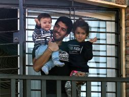 Luis Suárez sujeta a sus hijos Benjamín y Delfina desde una terraza ubicada en su casa de Lagomar, cerca de Montevideo. AFP /