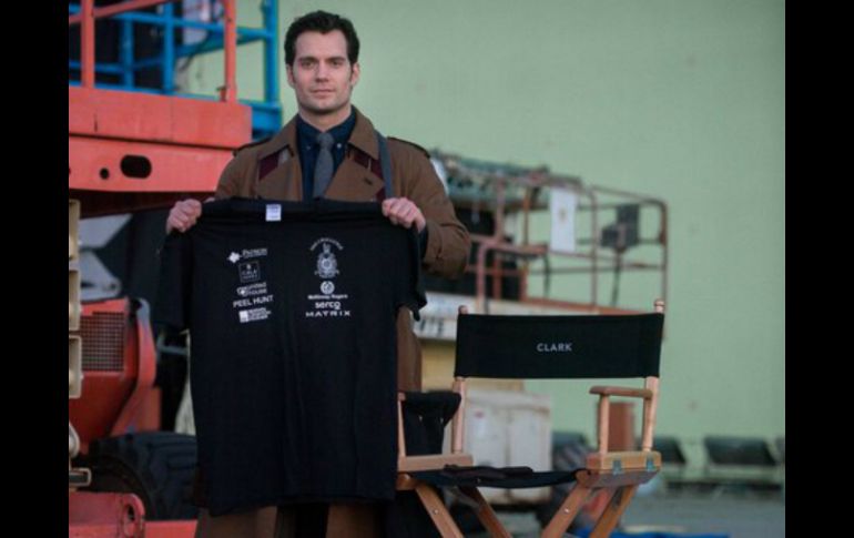 Cavill luce caracterizado como el alter ego de Superman y sosteniendo una playera de la fundación. ESPECIAL /