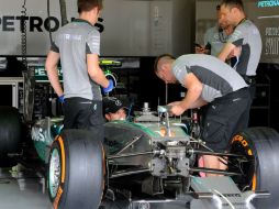 El piloto alemán de Mercedes, Nico Rosberg, platica con sus mecánicos en el garage de las 'Flechas plateadas'. AP /