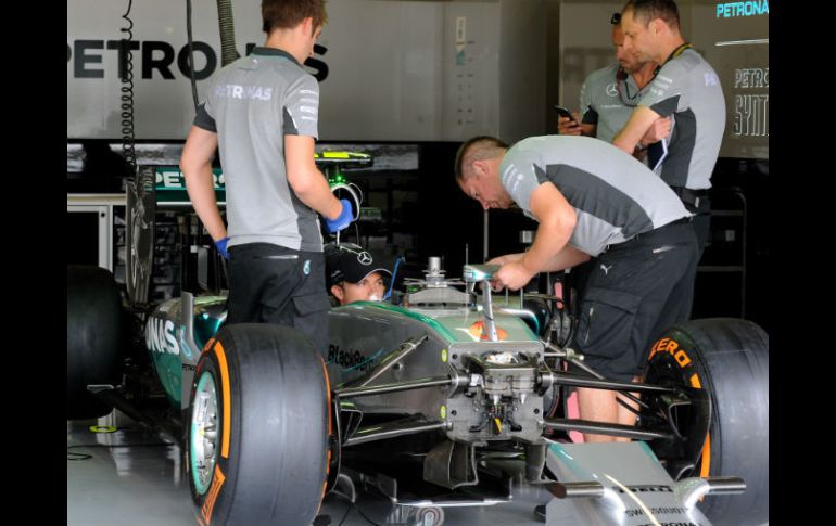 El piloto alemán de Mercedes, Nico Rosberg, platica con sus mecánicos en el garage de las 'Flechas plateadas'. AP /