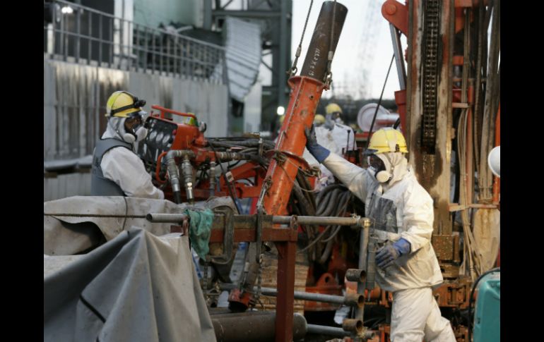 Obreros preparan pipas para construir el muro de hielo subterráneo. AFP /