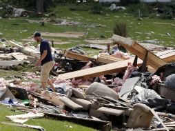 Residentes de Smithfield, el pueblo rural del centro de Nueva York, revisan los escombros de lo que queda de sus viviendas. AP /