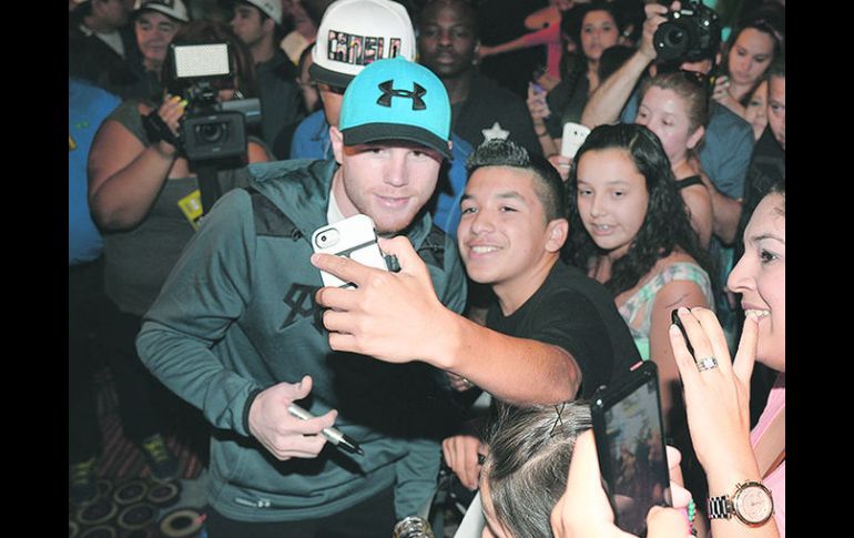 El 'Canelo' Álvarez se tomó fotografías con los aficionados que se dieron cita al entrenamiento público. ESPECIAL /