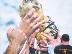 Argentinos posan ante un anuncio de la Copa del Mundo. AFP /