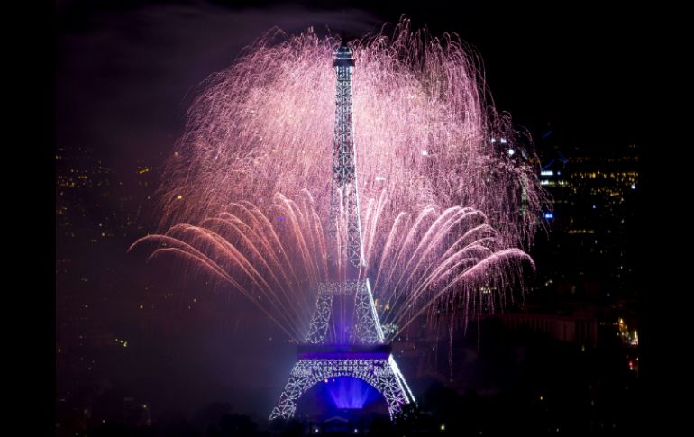 Los fuegos artificiales, lanzados desde la Torre Eiffel, están dedicados a la temática de guerra y paz. AFP /