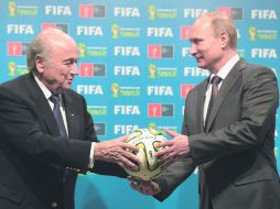 Blatter entregó al presidente de Rusia, Vladimir Putin, un balón Brazuca como señal del relevo entre Brasil 2014 y Rusia 2018. AP /