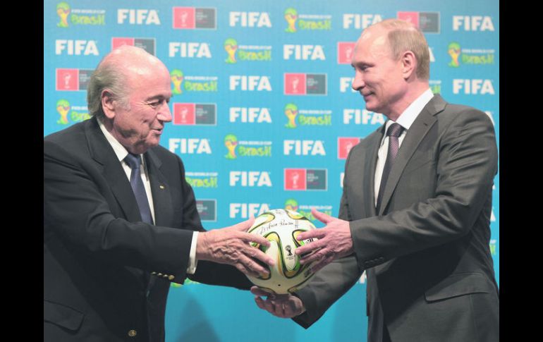 Blatter entregó al presidente de Rusia, Vladimir Putin, un balón Brazuca como señal del relevo entre Brasil 2014 y Rusia 2018. AP /