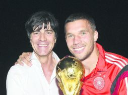 Arquitecto. Al seleccionador germano Joachim Löw (izq) y al futbolista Lukas Podolski mientras posan con la Copa del Mundo. EFE /