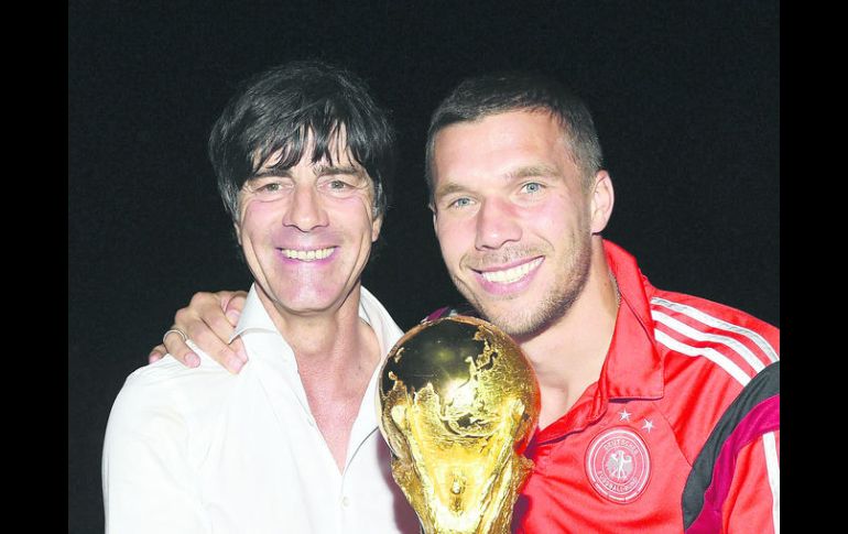 Arquitecto. Al seleccionador germano Joachim Löw (izq) y al futbolista Lukas Podolski mientras posan con la Copa del Mundo. EFE /