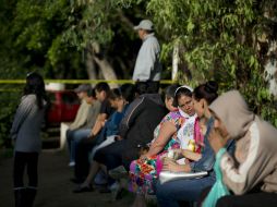 Familiares esperan noticias de los internos del albergue ''La Gran Familia'', luego del operativo y aseguramiento de ''Mamá Rosa''. AP /