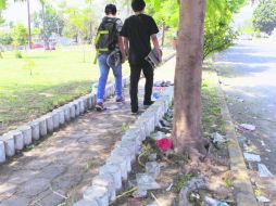 Un par de jóvenes contempla el abandono de la calle compartida por dos municipios.  /