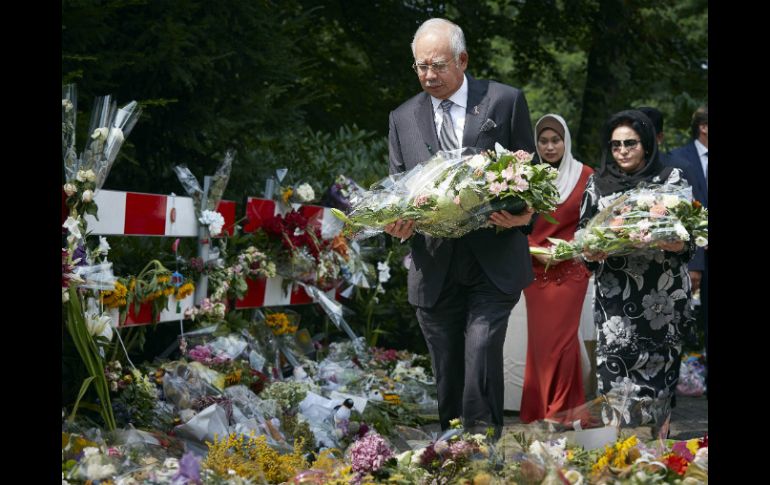 El primer ministro de Malasia, Najib Razak ofrecen un arreglo floral en memoría de las víctimas del vuelo de Malaysia Airlines. AP /