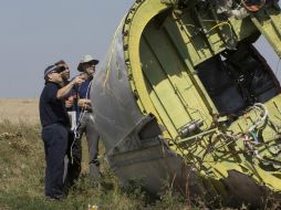 Forenses y especialistas en aviación de Holanda y Australia dedicaron varias horas a recorrer el campo donde cayó el avión. AP /