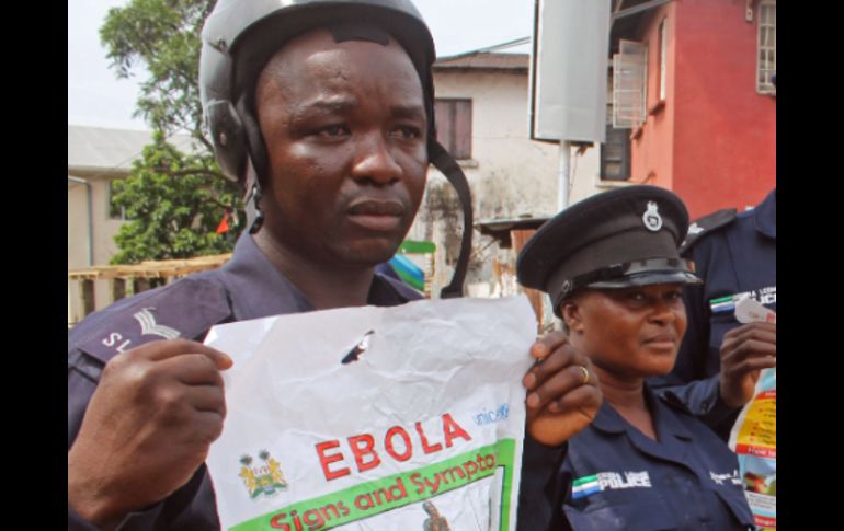 Agentes de la policía de Sierra Leona sostienen carteles en su intento de educar a la gente sobre el mortal virus. AP /