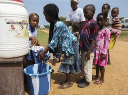 Niños liberianos son asistidos en el lavado de manos como parte del programa de sensibilización para evitar el contagio del ébola. EFE /