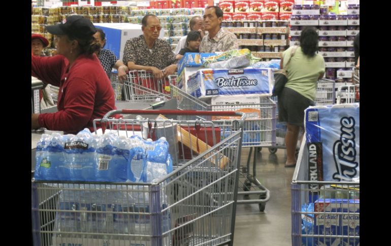 Los residentes se abastecen de botellas de agua, latas de carne y embutidos. AFP /