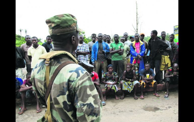 Medida. Soldados liberianos impiden a la gente viajar de zonas rurales afectadas por el brote de ébola a la capital del país. EFE /