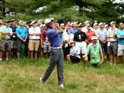 Tiger Woods realiza su tiro de aproximación desde el 'rough' en el primer hoyo. El estadonidense abrió con 'bogey'.  /