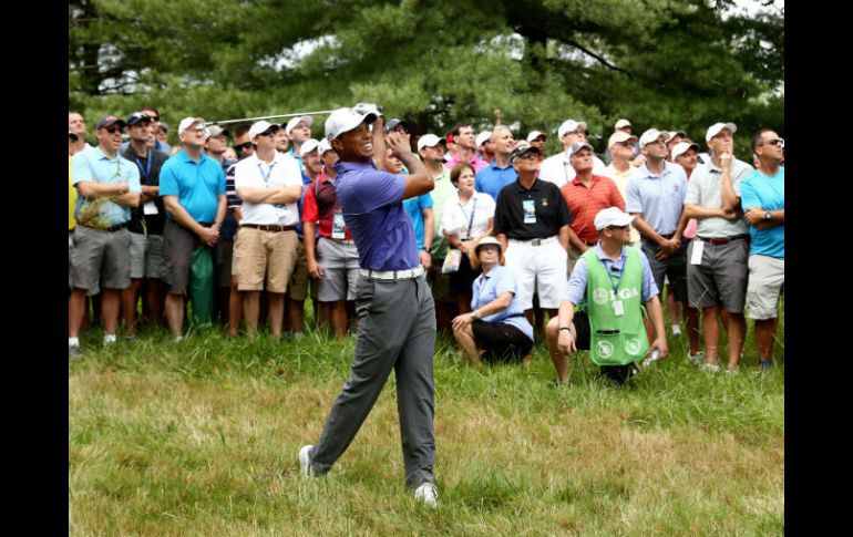 Tiger Woods realiza su tiro de aproximación desde el 'rough' en el primer hoyo. El estadonidense abrió con 'bogey'.  /