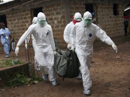 Enfermeros liberianos, con equipos de protección individual, trasladan el cuerpo de una víctima del ébola para su entierro. EFE /