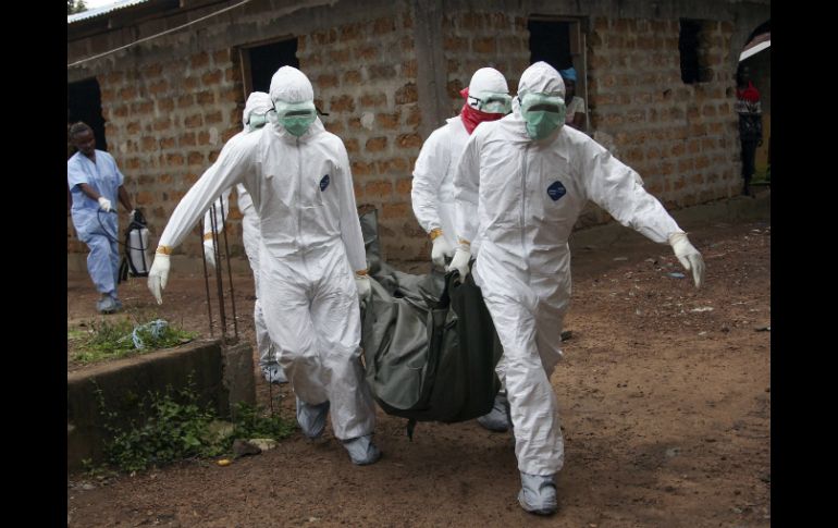 Enfermeros liberianos, con equipos de protección individual, trasladan el cuerpo de una víctima del ébola para su entierro. EFE /