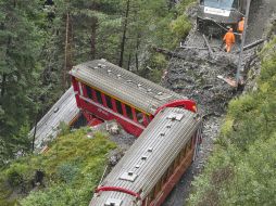 El impacto provocó que descarrilaran tres vagones, uno de los cuales quedó pendiendo al borde de un abismo. AFP /