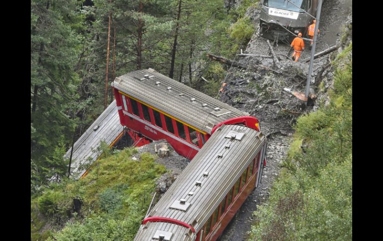 El impacto provocó que descarrilaran tres vagones, uno de los cuales quedó pendiendo al borde de un abismo. AFP /