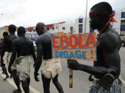 Un hombre sostiene un cartel que dice ''Ébola, desaparece'' como parte de una manifestación en Costa de Marfil. AFP /