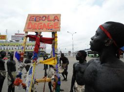 Miembros de un grupo de artistas sostienen una pancarta con el mensaje 'Ébola aléjate'. AFP /