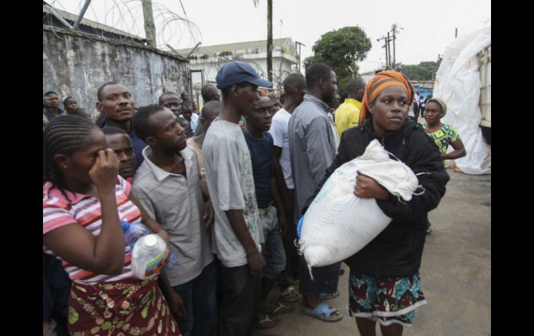 Ciudadanos liberianos reciben raciones de comida que distribuye el Gobierno como parte de su plan de cuarentena. EFE /