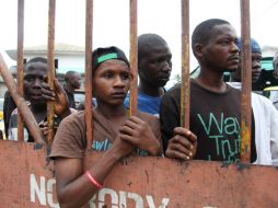 Residentes de Guinea esperan que les sean entregados alimentos como parte de un plan de cuarentena. ARCHIVO /