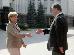 La canciller federal alemana, Angela Merkel es recibida en Kiev por el presidente de Ucrania, Petro Porosehnko. AP /