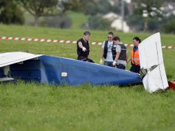 Policías inspeccionan las partes de las aeronaves que chocaron sobre el noroeste de Suiza. AP /