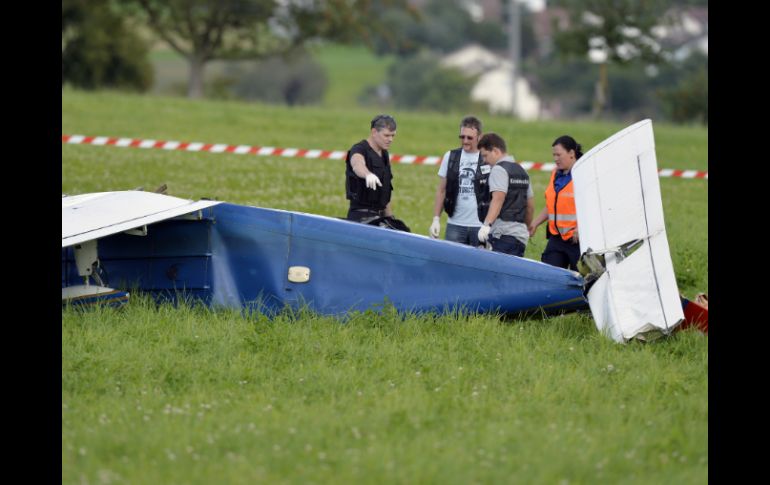 Policías inspeccionan las partes de las aeronaves que chocaron sobre el noroeste de Suiza. AP /