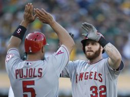 Albert Pujols felicita a Josh Hamilton, luego del cuadrangular que conectó el domingo ante Oakland. AFP /