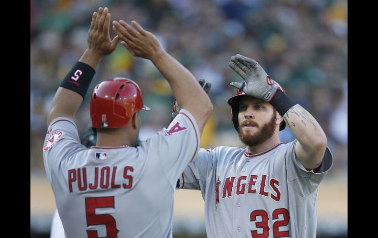 Albert Pujols felicita a Josh Hamilton, luego del cuadrangular que conectó el domingo ante Oakland. AFP /