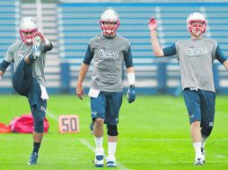 Los mariscales de Nueva Inglaterra, Jimmy Garoppolo, Tom Brady y Ryan Mallett, realizan estiramientos durante la práctica. AP /