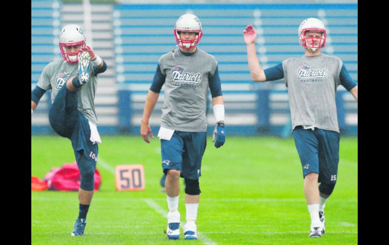 Los mariscales de Nueva Inglaterra, Jimmy Garoppolo, Tom Brady y Ryan Mallett, realizan estiramientos durante la práctica. AP /