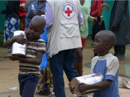 Un par de niños carga comida durante una campaña de ayuda en Liberia. La ONU estima que 1.3 millones de personas requieren asistencia. AFP /