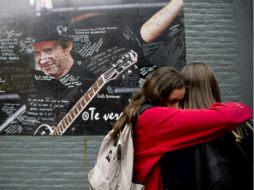 Fanáticos de Gustavo Cerati reaccionan tras conocer la noticia de su fallecimiento ayer, en Buenos Aires. AP /