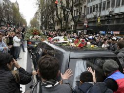 Miles de personas se congregan alrededor del coche fúnebre para dar el último adiós al músico. AFP /