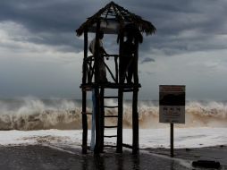 Dos hombres observan el fuerte oleaje debido a la influencia del huracán ''Norbert'', en una playa en el puerto de Mazatlán. EFE /