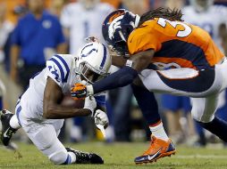 El receptor de Indianapolis, T.Y. Hilton, es derribado por Quinton Carter de los Broncos de Denver. AP /