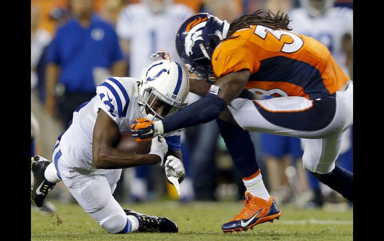 El receptor de Indianapolis, T.Y. Hilton, es derribado por Quinton Carter de los Broncos de Denver. AP /