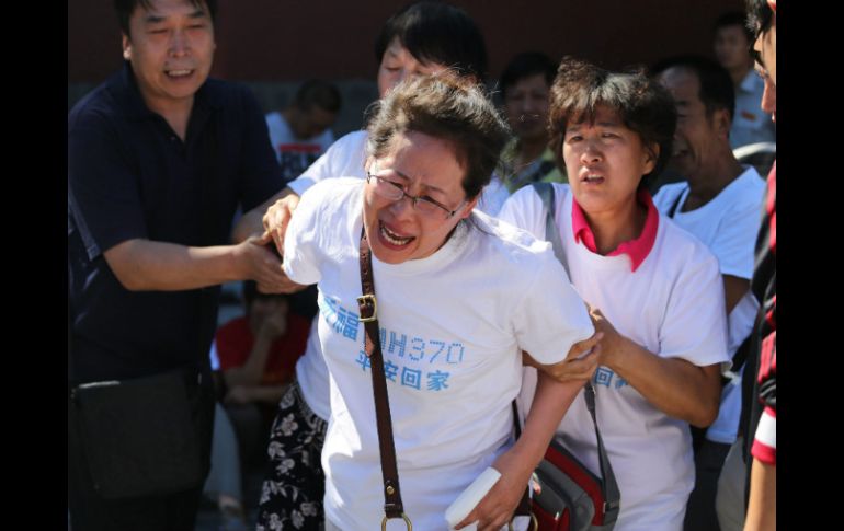 Consternados, los familiares, quienes portaban camisetas con el emblema MH370, recuerdan y oran por las víctimas. EFE /