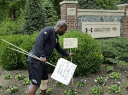 Gente de los Cuervos de Baltimore retira carteles en apoyo al jugador. AP P. Semansky  /