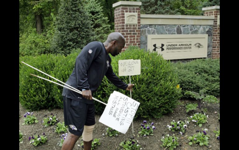 Gente de los Cuervos de Baltimore retira carteles en apoyo al jugador. AP P. Semansky  /