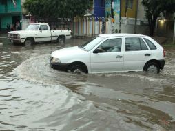 Un vehículo se abre paso por una calle inundada en Oaxaca. EFE /